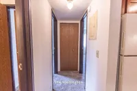 Inviting hallway leading to cozy bedrooms in The Wellington, a 2 Bed 1 Bath 900 sq ft apartment.