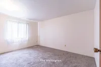 Bright and inviting bedroom in The Wellington apartment, featuring plush carpet and ample natural light, 2 Bed, 1 Bath, 900 sq ft.