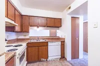 Inviting kitchen in The Wexford apartment featuring warm wooden cabinetry and modern amenities, ideal for cozy living.