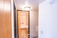 Inviting hallway leading to a well-lit bathroom with classic tiles, inside The Wexford's cozy 1 bed, 1 bath unit spanning 690 sq. ft.