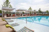 Luxurious outdoor pool area with stylish lounge chairs and elegant cabanas, perfect for relaxation.