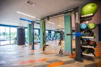 Vibrant and modern apartment gym featuring state-of-the-art fitness equipment, bright natural lighting, and a variety of workout options.