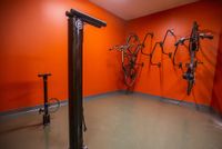 Vibrant orange bike storage room featuring secure wall-mounted racks and convenient pump station.
