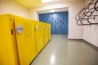 Modern apartment amenities featuring bright yellow bike storage lockers and secure wall-mounted racks, offering convenience and style.