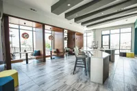 Contemporary lounge area with plush seating and modern decor, featuring elegant pendant lighting and large windows for natural light.