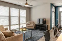 Bright, modern living room with stylish decor, featuring a plush sofa, sleek armchair, and a contemporary glass coffee table.