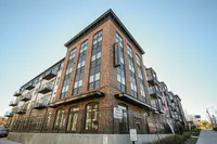 Modern brick apartment complex with large windows and balconies, featuring stylish urban design and strategic location.
