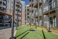 Modern apartment building with private balconies and well-maintained recreational green space, perfect for outdoor activities.