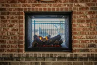 Charming brick fireplace with cozy logs glowing warmly, creating an inviting ambiance.