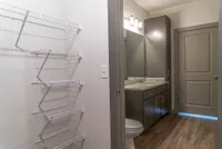 Modern bathroom with elegant granite countertop, sleek cabinetry, and ample shelving for convenient storage.