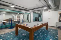 Modern recreational area with a stylish pool table, chic seating, and vibrant decor, perfect for entertainment and relaxation.