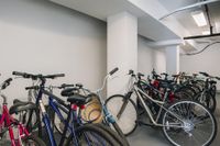 Secure and spacious indoor bicycle storage area with multiple bikes neatly organized, ideal for active residents.