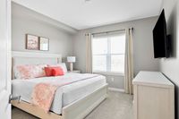 Bright and inviting bedroom with a cozy bed, elegant decor, and large sunlit window, perfect for relaxation and comfort.
