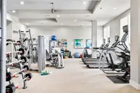 Modern fitness center featuring state-of-the-art equipment, treadmills, weight machines, and bright natural lighting.