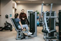 Modern apartment gym featuring state-of-the-art fitness machines and personal training opportunities.