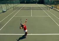 Dynamic tennis match on a sunlit outdoor court with players in action, showcasing athleticism and competitive spirit.