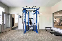 Modern apartment gym featuring state-of-the-art multi-functional exercise equipment under bright natural lighting.
