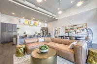 Modern open-concept living area with luxurious leather seating, stylish pendant lighting, and chic decor perfect for entertaining.