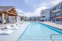 Luxurious apartment complex with stunning outdoor pool area, modern poolside loungers, and stylish communal spaces.