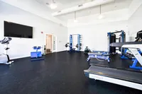 Bright and modern fitness center equipped with treadmills, weightlifting machines, and exercise bikes, perfect for a dynamic workout experience.
