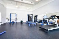 Bright and modern fitness center equipped with state-of-the-art gym equipment, including treadmill and weights, perfect for a healthy lifestyle.