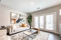 Contemporary living room with elegant decor, large abstract artwork, plush sofa, and abundant natural light.