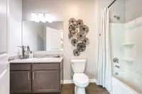 Elegant bathroom with sleek vanity, modern fixtures, and unique wall art, offering a serene and stylish space.