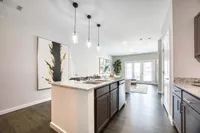 Modern open-concept kitchen and living area with sleek granite countertops, stylish pendant lighting, and chic decor.