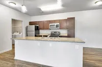 Modern kitchen with sleek countertops, stainless steel appliances, and elegant cabinetry providing a spacious and inviting cooking area.
