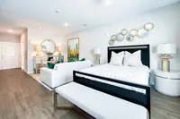 Chic open-layout apartment showcasing a stylish bedroom with contemporary decor, complemented by an elegant living area and exquisite artwork.