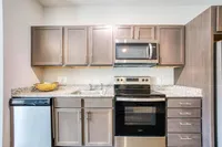 Modern kitchen with sleek stainless steel appliances, elegant granite countertops, and stylish cabinetry.