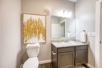 Contemporary bathroom design with elegant granite countertop, chic wall art, and modern lighting.