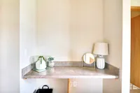 Chic corner space with decorative elements, featuring a stylish lamp, a modern mirror, and elegant plants for a cozy ambiance.