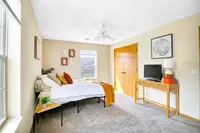 Bright and cozy bedroom with modern decor, featuring a comfortable bed, stylish artwork, and ample natural light.