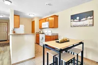 Cozy kitchen with modern appliances, warm wooden cabinetry, and a stylish dining area perfect for gatherings.