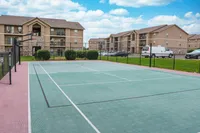 Inviting outdoor basketball court with modern apartment buildings in the background, offering a vibrant community lifestyle.