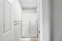 Modern bathroom with sleek frosted glass shower doors and fresh white walls, offering a crisp and clean aesthetic.