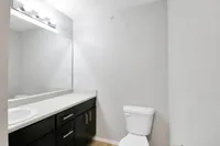 Bright and modern bathroom with sleek fixtures, large mirror, and ample countertop space.