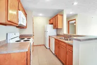 Bright and welcoming kitchen with modern appliances, elegant wooden cabinetry, and ample counter space.
