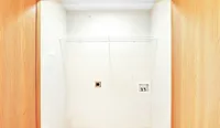 Bright and spacious laundry nook with modern wood accents and utility hookups, perfect for convenient at-home laundry.