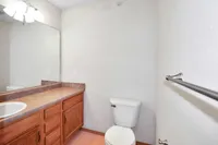 Bright and inviting bathroom featuring a large mirror, elegant wooden vanity, and modern fixtures.