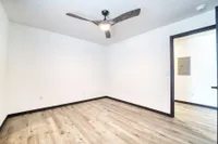Bright room showcasing modern ceiling fan, sleek wood flooring, and minimalist design.