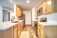 Modern kitchen with warm wood cabinetry, sleek countertops, and stainless steel appliances, perfect for culinary adventures.