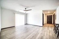 Bright and modern living area with elegant wood flooring, large sliding doors, and stylish ceiling fan.