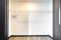 Spacious walk-in closet with sleek shelving and modern flooring, perfect for maximizing storage in a stylish apartment.
