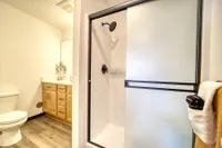 Modern bathroom design featuring elegant walk-in shower with glass door, stylish wooden cabinets, and sleek flooring.