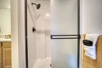 Modern bathroom featuring a sleek glass shower enclosure and stylish fixtures with a cozy towel setup.