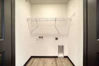 Bright utility room with modern hookups, sleek shelving, and elegant flooring, perfect for efficient laundry tasks.