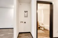 Inviting apartment interior featuring modern bathroom access and sleek hardwood flooring.