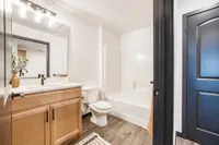 Modern bathroom featuring sleek fixtures, a spacious vanity, elegant lighting, and a pristine bathtub, offering a serene retreat.